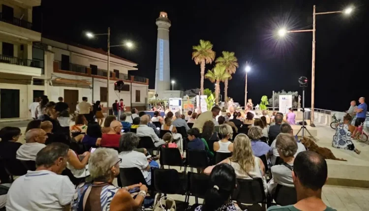 Pubblico seduto in Piazza Belvedere a Punta Secca durante un incontro serale di Libri d'aMare