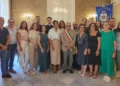 Gruppo di circa venti persone in posa nella Sala degli Specchi di Palazzo Iacono a Vittoria, con fascia tricolore e gonfalone del Comune