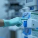 Mano guantata indica un dispositivo medico ospedaliero con etichette di manutenzione e calibrazione