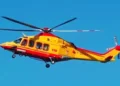 Elicottero del 118 in volo su cielo azzurro, livrea giallo-rossa, impegnato in un intervento di soccorso sanitario.