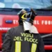 Vigili del fuoco di spalle davanti a un mezzo antincendio durante un intervento