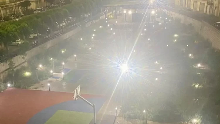 Area giochi e campo sportivo dell'ex mercato ortofrutticolo di Modica illuminati di notte da forti faretti esterni.