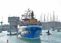 Il simulacro di Santa Maria di Portosalvo trasportato su un peschereccio blu nel porto di Marina di Ragusa, circondato da piccole imbarcazioni