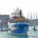 Il simulacro di Santa Maria di Portosalvo trasportato su un peschereccio blu nel porto di Marina di Ragusa, circondato da piccole imbarcazioni