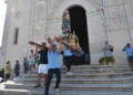 Portatori in maglietta azzurra trasportano la statua di Maria Santissima di Portosalvo fuori dalla chiesa, Marina di Ragusa.