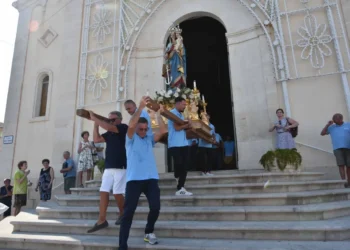Portatori in maglietta azzurra trasportano la statua di Maria Santissima di Portosalvo fuori dalla chiesa, Marina di Ragusa.