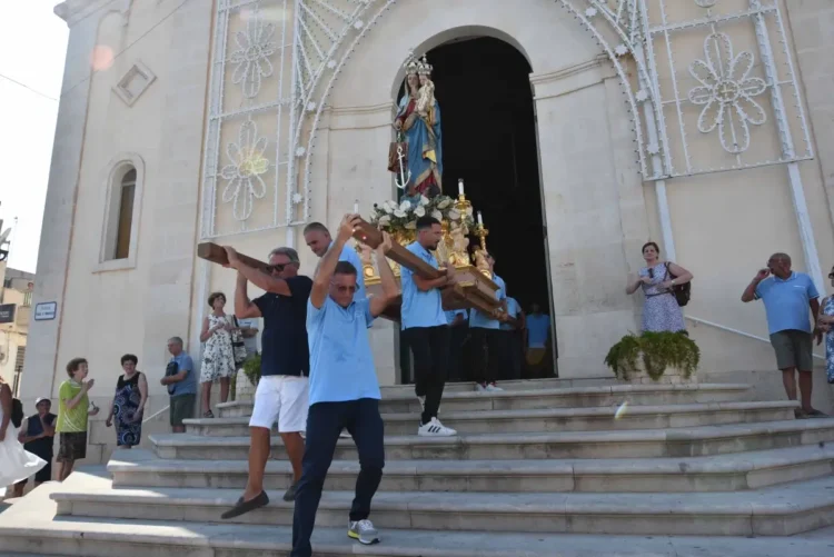 Portatori in maglietta azzurra trasportano la statua di Maria Santissima di Portosalvo fuori dalla chiesa, Marina di Ragusa.