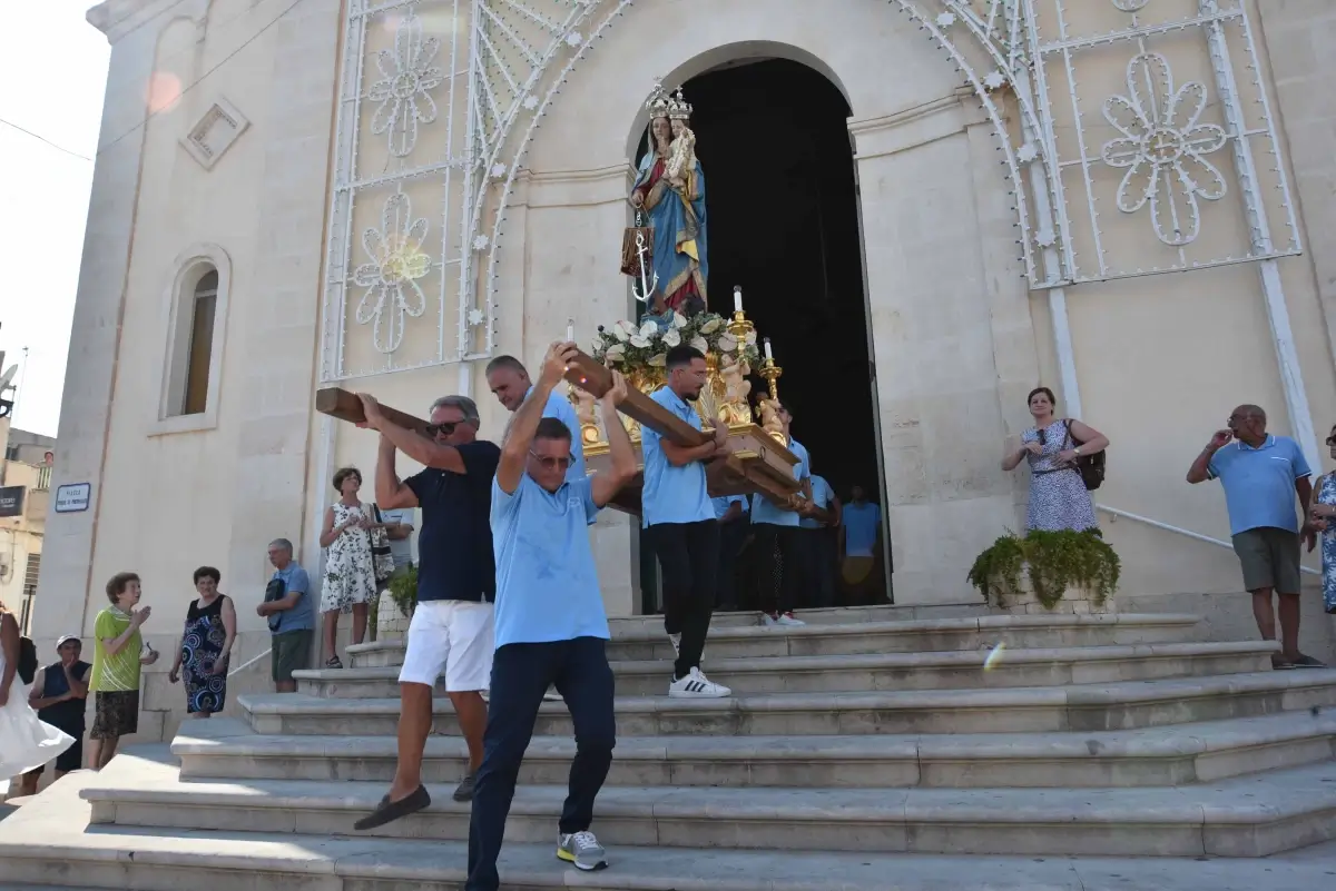 Portatori in maglietta azzurra trasportano la statua di Maria Santissima di Portosalvo fuori dalla chiesa, Marina di Ragusa.