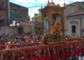 Il fercolo dorato di San Bartolomeo portato a spalla dai fedeli tra la folla nelle vie di Giarratana