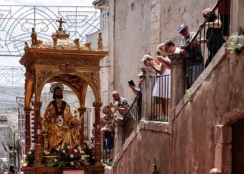 Simulacro dorato di San Bartolomeo in processione tra i vicoli, fedeli fotografano dai balconi