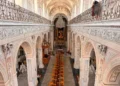 Interno barocco della chiesa madre di Monterosso Almo con matronei, lampadari e banchi in legno allineati verso l'altare