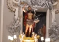 Statua di San Giovanni Battista nella nicchia dorata della cattedrale di Ragusa, con candelabri accesi alla base