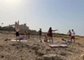 Gruppo di persone con tappetini da yoga davanti alla Fornace di Punta Pisciotto a Sampieri, durante le riprese di Rai Uno.