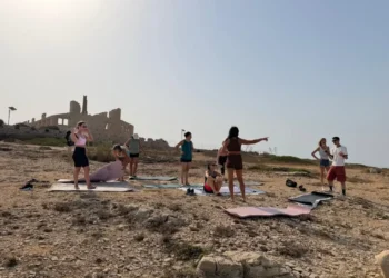 Gruppo di persone con tappetini da yoga davanti alla Fornace di Punta Pisciotto a Sampieri, durante le riprese di Rai Uno.