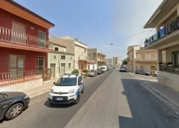 Fiancata di un'auto della Polizia Locale, primo piano dello sportello anteriore con scritta blu su fondo bianco.