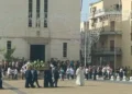Feretro con fiori bianchi portato in piazza davanti alla chiesa di Santa Maria di Portosalvo a Scoglitti