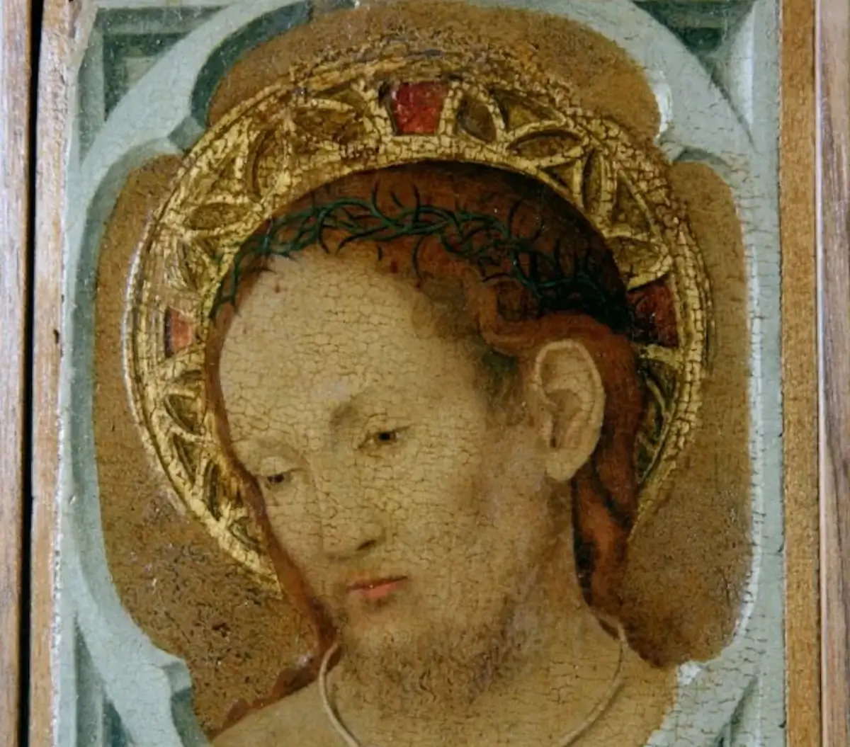 Dettaglio del volto di Cristo con corona di spine e aureola dorata, dal dipinto Cristo in pietà di Antonello da Messina.