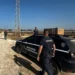 Due guardie giurate dell'istituto La Sicurezza ispezionano una stradina sterrata accanto a un parco fotovoltaico in aperta campagna.