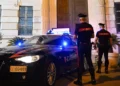 Pattuglia dei Carabinieri e due militari davanti alla caserma durante un servizio notturno