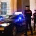 Pattuglia dei Carabinieri e due militari davanti alla caserma durante un servizio notturno