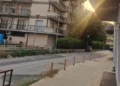 Una via residenziale di Modica con marciapiede, dissuasori e cassonetti per la raccolta differenziata, al tramonto