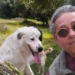 Giovanna Cicero Molè in un selfie all'aperto con un cane bianco, tra alberi e campagna verde.
