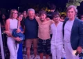 Gruppo di persone posa insieme durante un evento serale all'aperto