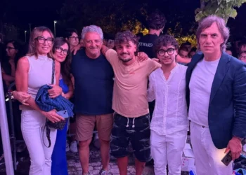 Gruppo di persone posa insieme durante un evento serale all'aperto