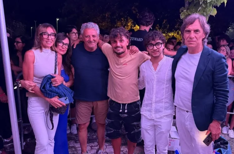 Gruppo di persone posa insieme durante un evento serale all'aperto