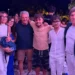 Gruppo di persone posa insieme durante un evento serale all'aperto