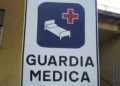 Cartello stradale bianco con scritta "Guardia Medica" e simbolo di letto ospedaliero con croce rossa su sfondo blu