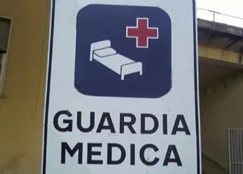 Cartello stradale bianco con scritta "Guardia Medica" e simbolo di letto ospedaliero con croce rossa su sfondo blu