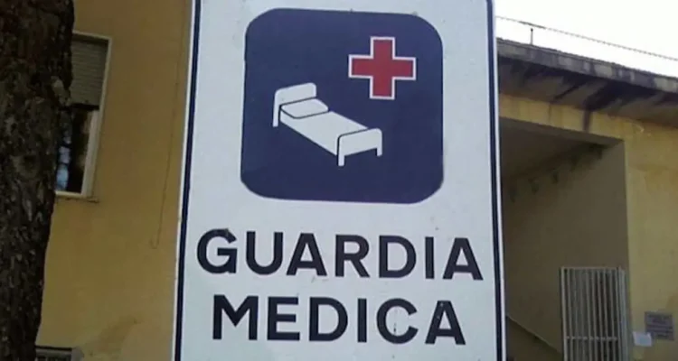 Cartello stradale bianco con scritta "Guardia Medica" e simbolo di letto ospedaliero con croce rossa su sfondo blu