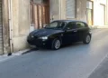 Auto scura ferma contro un muro in una strada di Modica