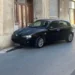Auto scura ferma contro un muro in una strada di Modica