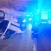 Fiat Panda bianca rovesciata sul fianco della strada di notte, con mezzo dei Vigili del Fuoco e luci blu sullo sfondo