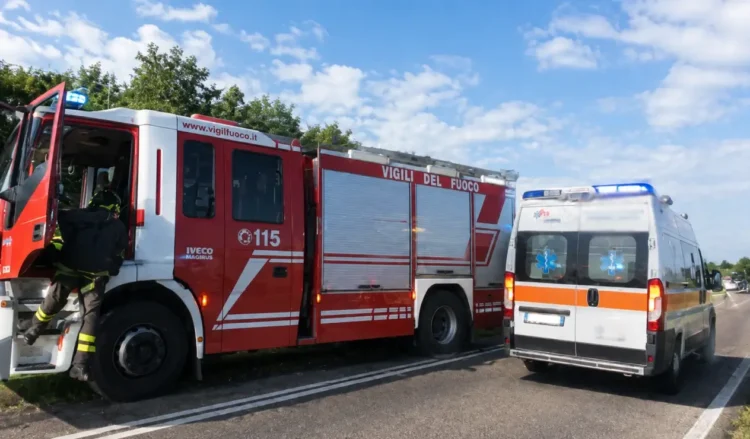 Autopompa dei vigili del fuoco e ambulanza del 118 fermi sul bordo di una strada durante un intervento di soccorso