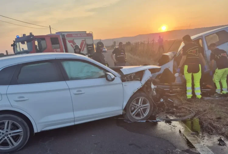 Scontro frontale sulla SP 15 di Vittoria al tramonto: vigili del fuoco e operatori del 118 al lavoro sui veicoli coinvolti.