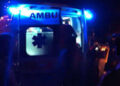 Ambulanza del 118 con lampeggianti blu accesi nella notte, portiere posteriori aperte e un soccorritore accanto al mezzo.