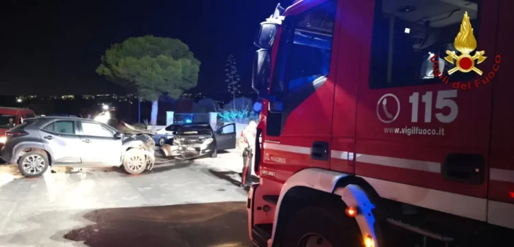 Due auto schiacciate dopo uno scontro frontale, con un mezzo dei Vigili del Fuoco sul posto di notte.