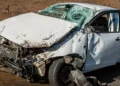 Auto bianca con il muso distrutto e il parabrezza sfondato dopo un incidente stradale.
