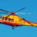 Elicottero del servizio di elisoccorso in volo su cielo azzurro, livrea gialla e rossa con scritta 118