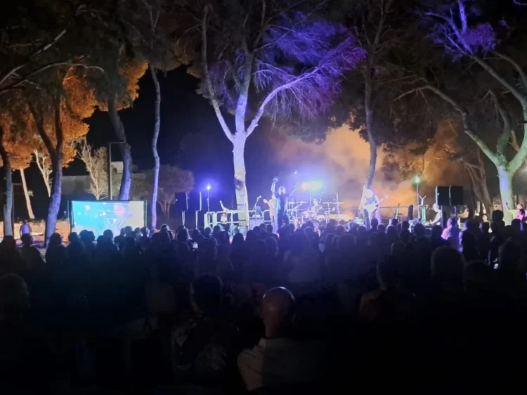 Folla numerosa di spalle assiste al concerto dei Queentessenza tra gli alberi del Parco di Caucana