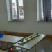 Aula scolastica vuota con banchi, sedie e finestre con vetri colorati durante i lavori estivi di manutenzione