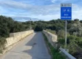 Cartello della SP18 Noto Giarratana su un ponte immerso nella campagna