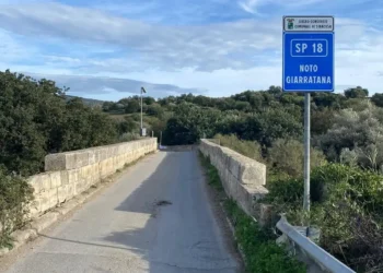 Cartello della SP18 Noto Giarratana su un ponte immerso nella campagna