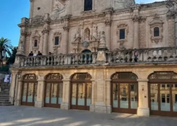 Il loggiato al piano terra della Cattedrale di San Giovanni Battista a Ragusa, con infissi in legno e vetro affacciati sulla piazza