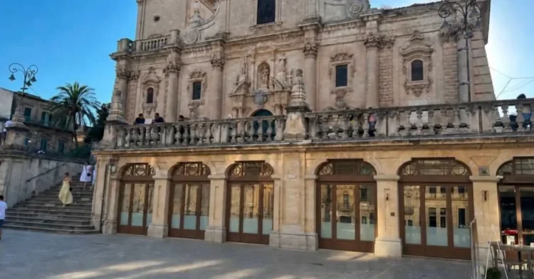 Il loggiato al piano terra della Cattedrale di San Giovanni Battista a Ragusa, con infissi in legno e vetro affacciati sulla piazza