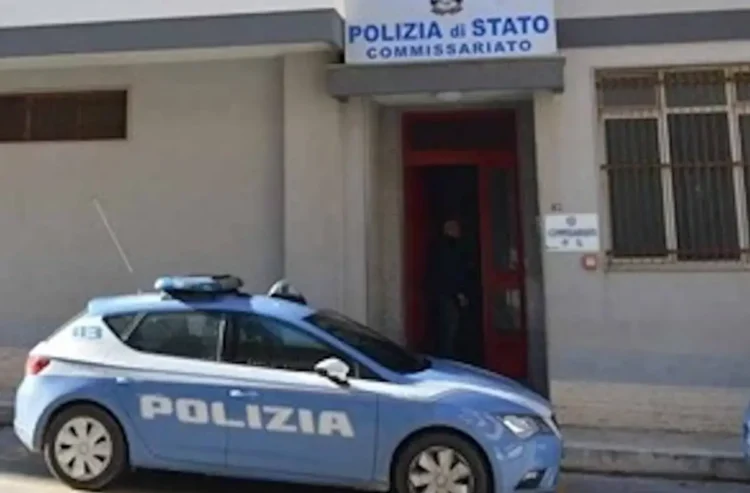 Auto della Polizia di Stato parcheggiata davanti all'ingresso di un commissariato con insegna sulla facciata