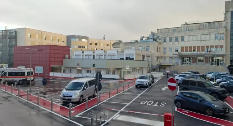 Parcheggio e ingresso dell'ospedale Guzzardi di Vittoria con ambulanza in sosta, ripreso in una giornata nuvolosa
